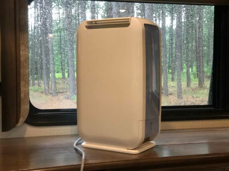 an RV dehumidifier sitting on the counter with a wet window behind it