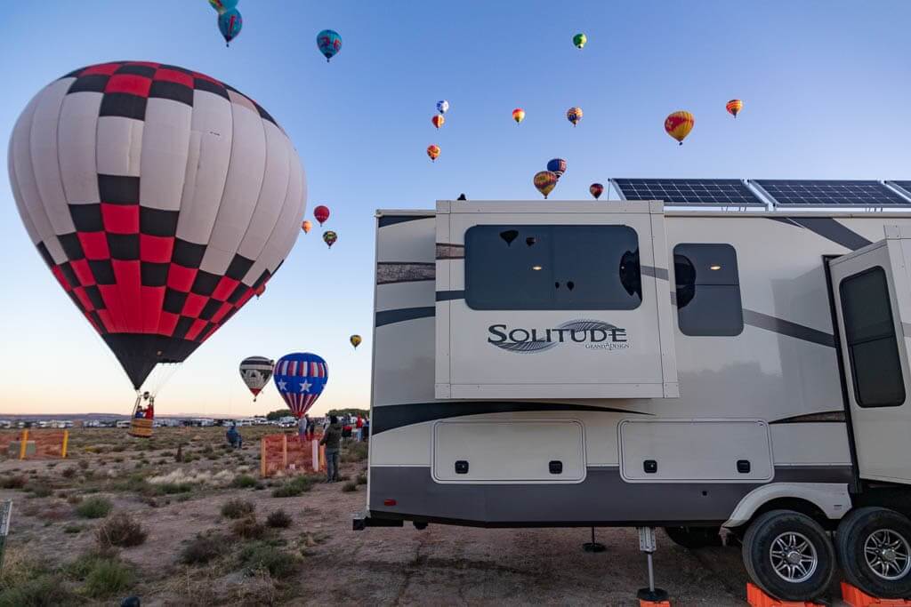 Getaway Couple's RV at the Albuquerque Ballon Fiesta with a hot air ballon landing right behind the RV.