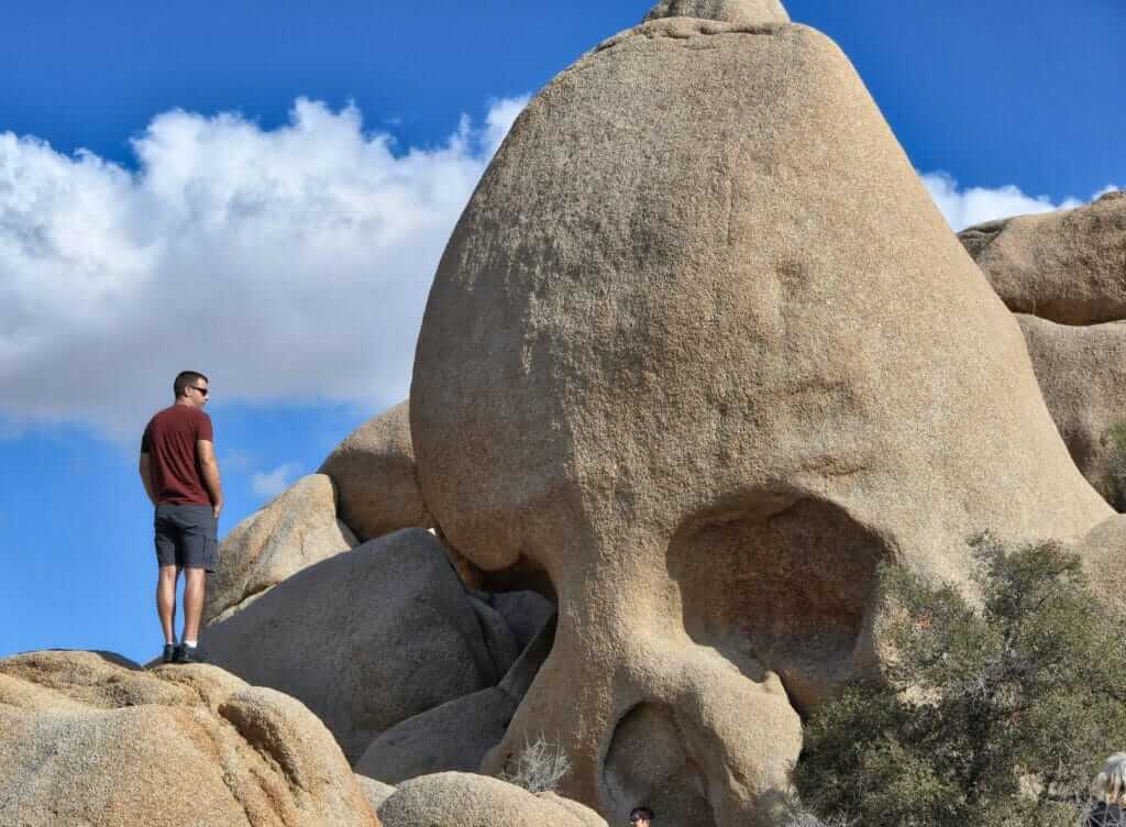 Man standing next to Skull Rock 