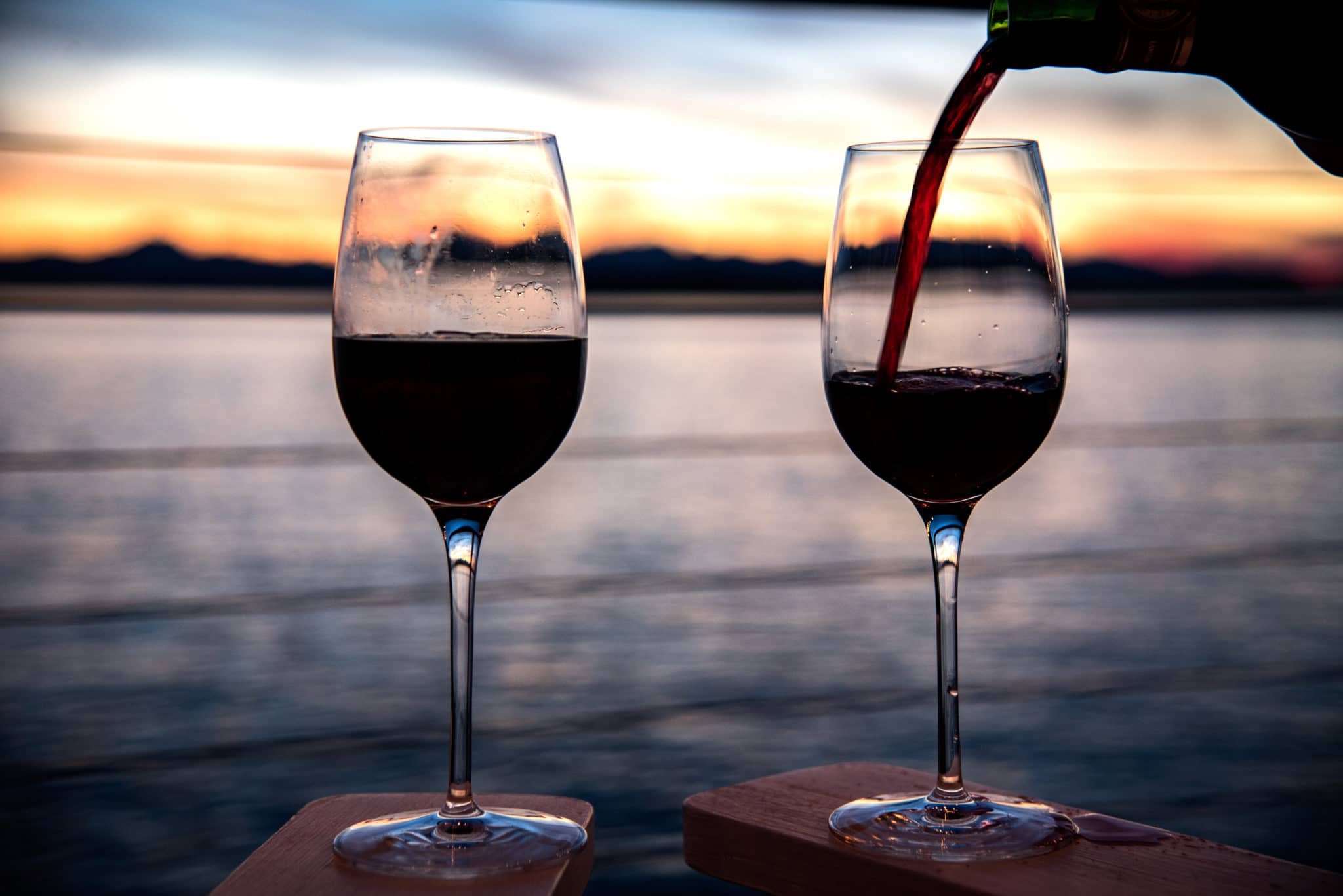 Wine being poured into two glasses at sunset at a Florida Harvest Host 