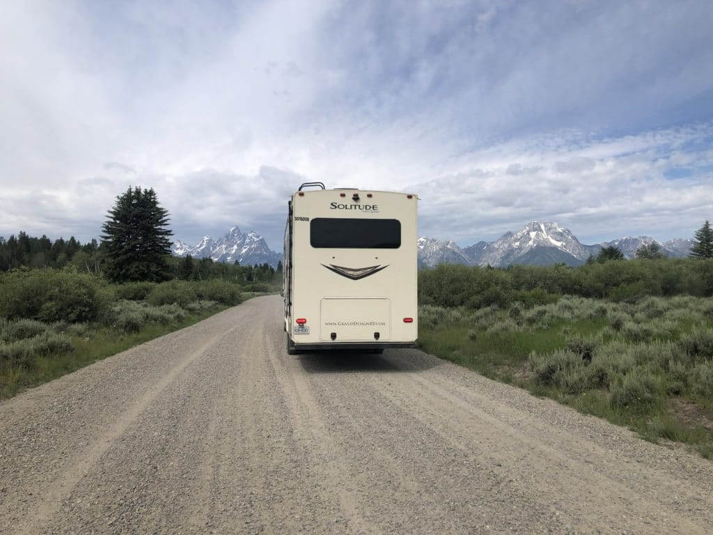 Large picture window in the back of a fifth wheel parked in front of the Grand Tetons
