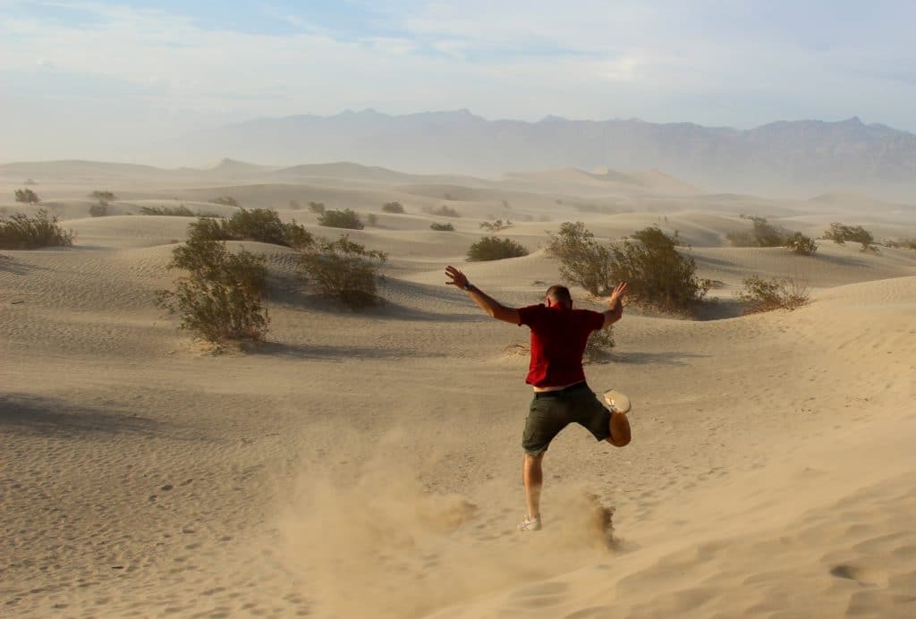 Man running down dunes at Mesquite Flats Sand Dunes in Death Valley National Park