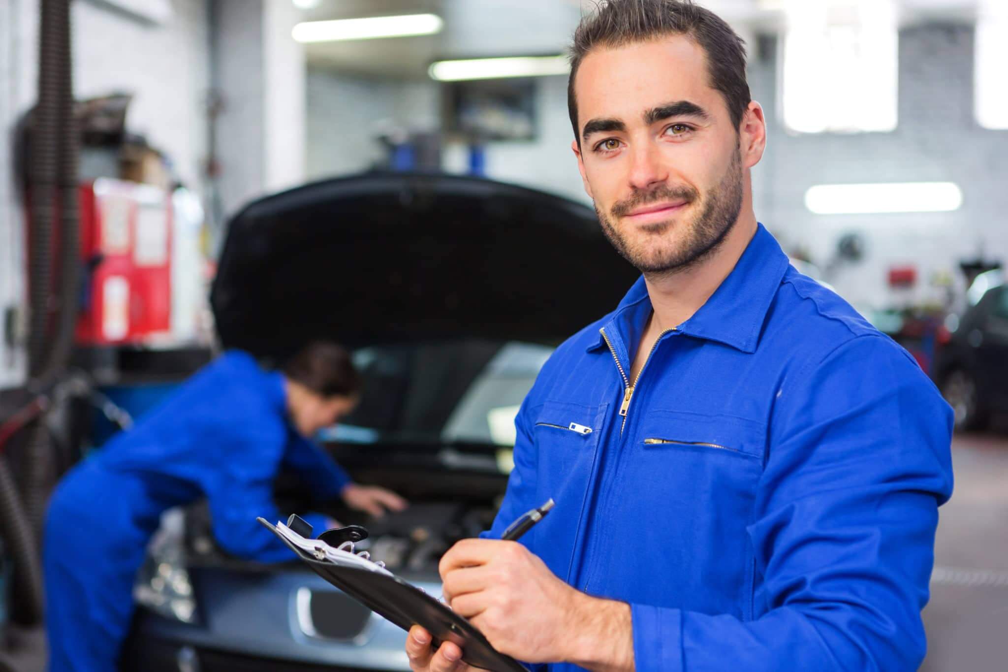 View of a Young attractive mechanic working at the garage