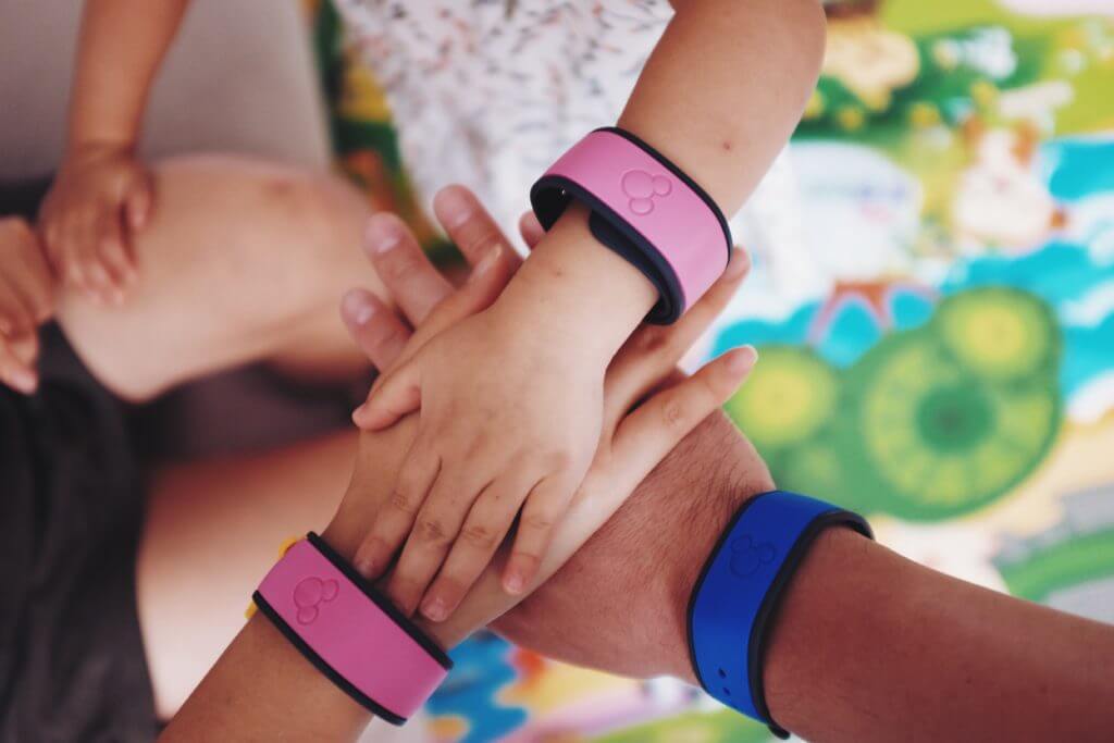 Family with hands in the middle showing their Disney World annual pass bracelets