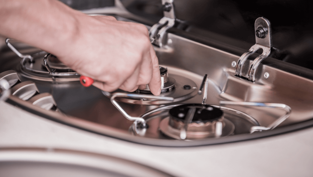 An RV stove burner is being repaired which is why it's important to know how long are RV warranties