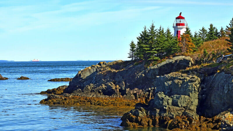 The atlantic ocean surrounds an island and lighthouse that hold the only US National Park in Canada.