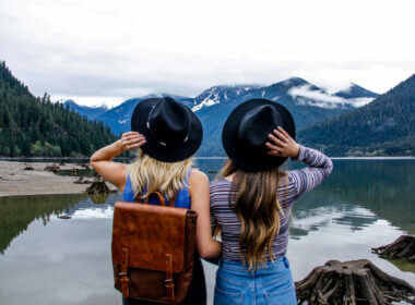 Two girls standing at edge of a lake in a national park while visiting on a free day.