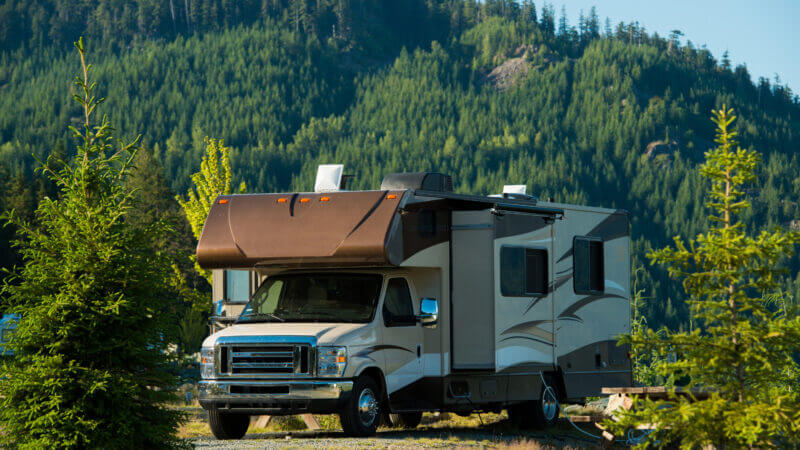 A tall RV is parked in a forest. Do you know how tall your RV is?