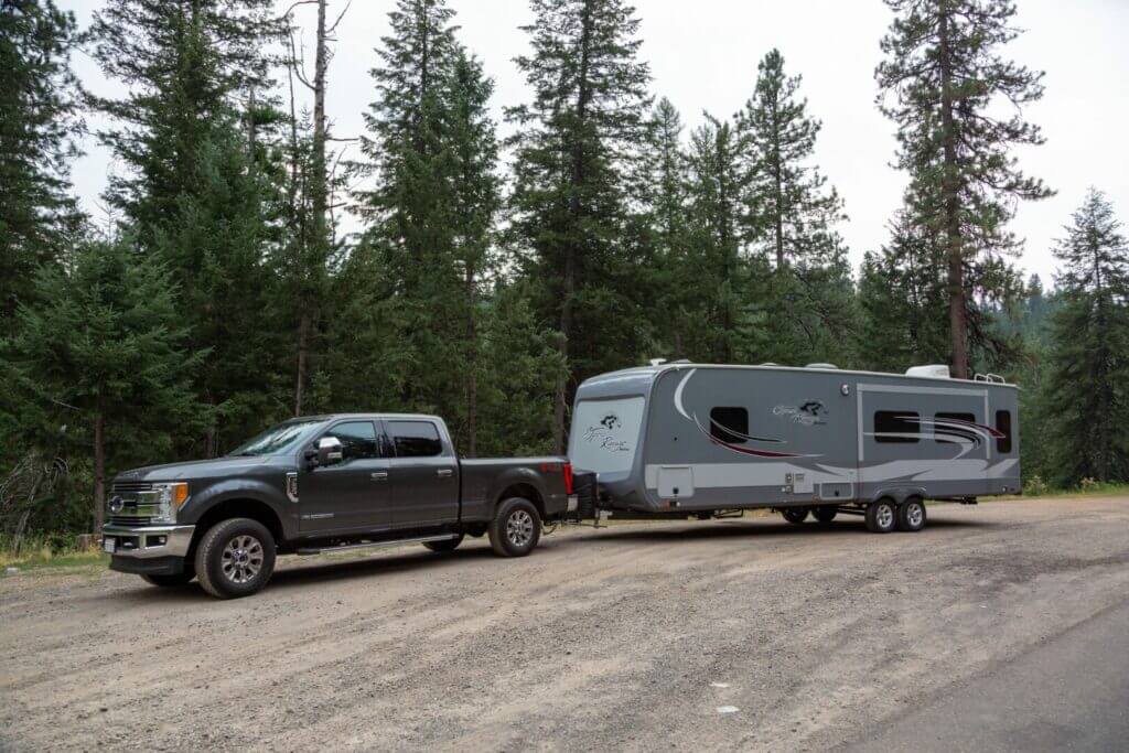 A truck towing a travel trailer pulled off into a pre-designated area meant for boondocking. This is proper boondocking etiquette. 