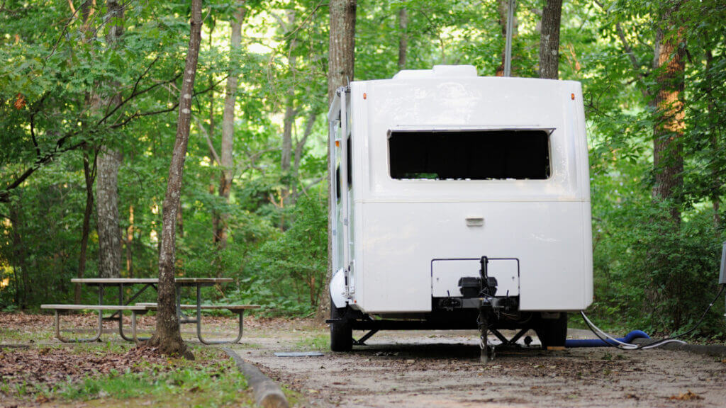 An unattended trailer at a campground is safe from thieves because the owners secured it with a trailer hitch lock.