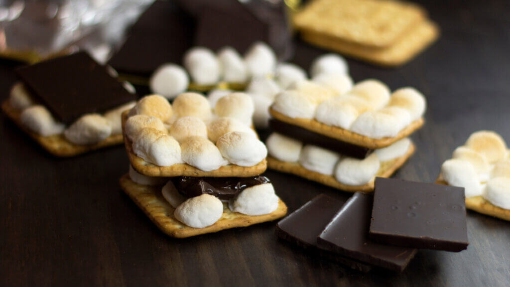 Frozen smores are one of the best smore recipes. Stacked layers of smores cover each other with additional chocolate piled nearby. 