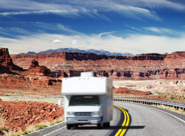 An RV drives down the highway in a blur in the desert (maybe Grand Canyon?). If you wanted to get one for a vacation, how much would it cost to rent an RV?