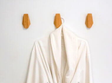 A white robe hangs on the wall thanks to Command Strip products, so you don't have to drill into the walls of your RV to hang things up!