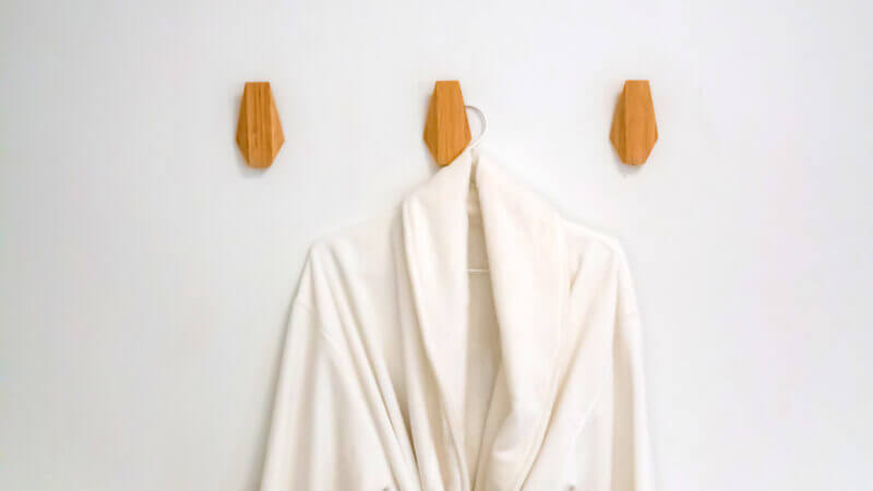 A white robe hangs on the wall thanks to Command Strip products, so you don't have to drill into the walls of your RV to hang things up!