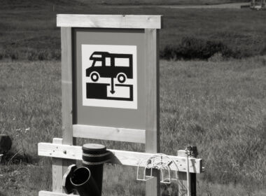 A black and white image of an RV dump station. What is an RV Black Tank?