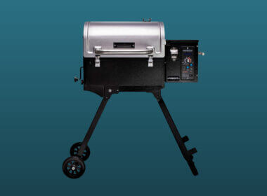 A camp chef portable pellet grill set against a dark blue backdrop.