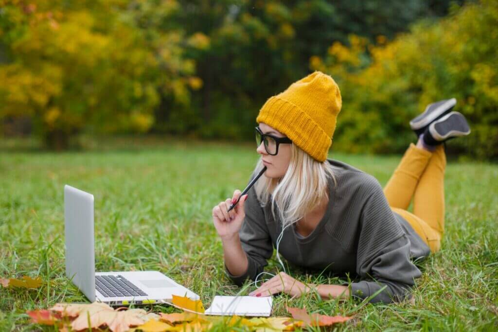 Woman sitting outside with her laptop trying to make a national park reservation
