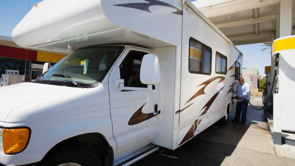 A man fills his RV gas tank which can be a very expensive RV ownership cost!