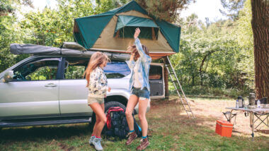 Two girls dance at the campsite because their camping playlist rocks!