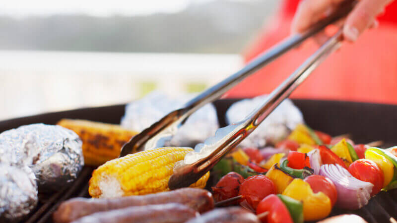 Someone is flipping veggies on a grill but which is better? Green mountain grills vs Traeger?