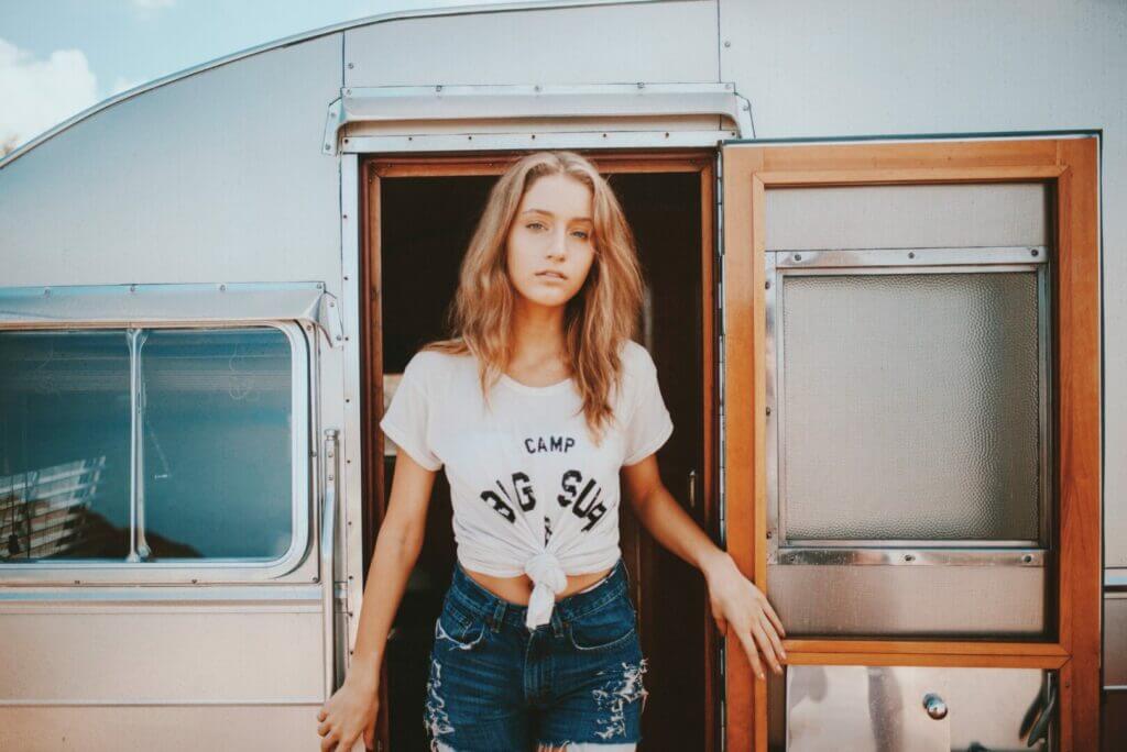 woman standing in the door of a small camper trailers