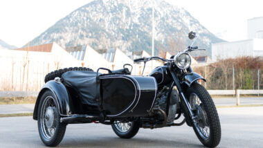 A travel motorcycle is parked in front of the mountain ready for the road. All it needs is a travel camper to tow along and camp comfortably.