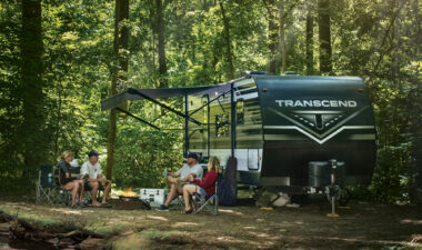 Grand Design Transcend Travel Trailer parked in forest campground