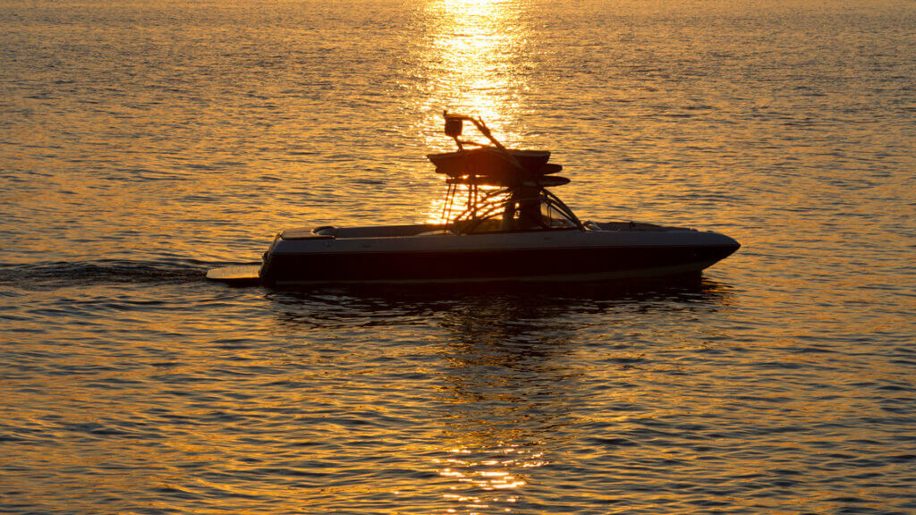 A boat scuttles along Lake Piru in the sunset glow.