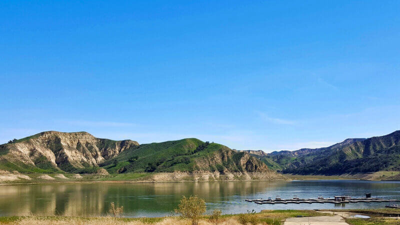 A blue sky day at Lake Piru is not uncommon with rolling hills along the shoreline.
