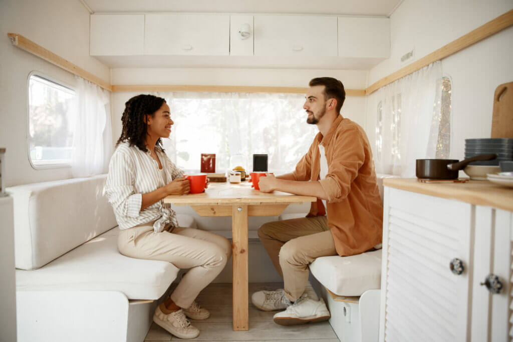 Man and woman enjoying coffee inside their RV.