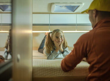 A girl lays on an RV mattress and looks happily at her dad. What RV sheets are best for their mattress?