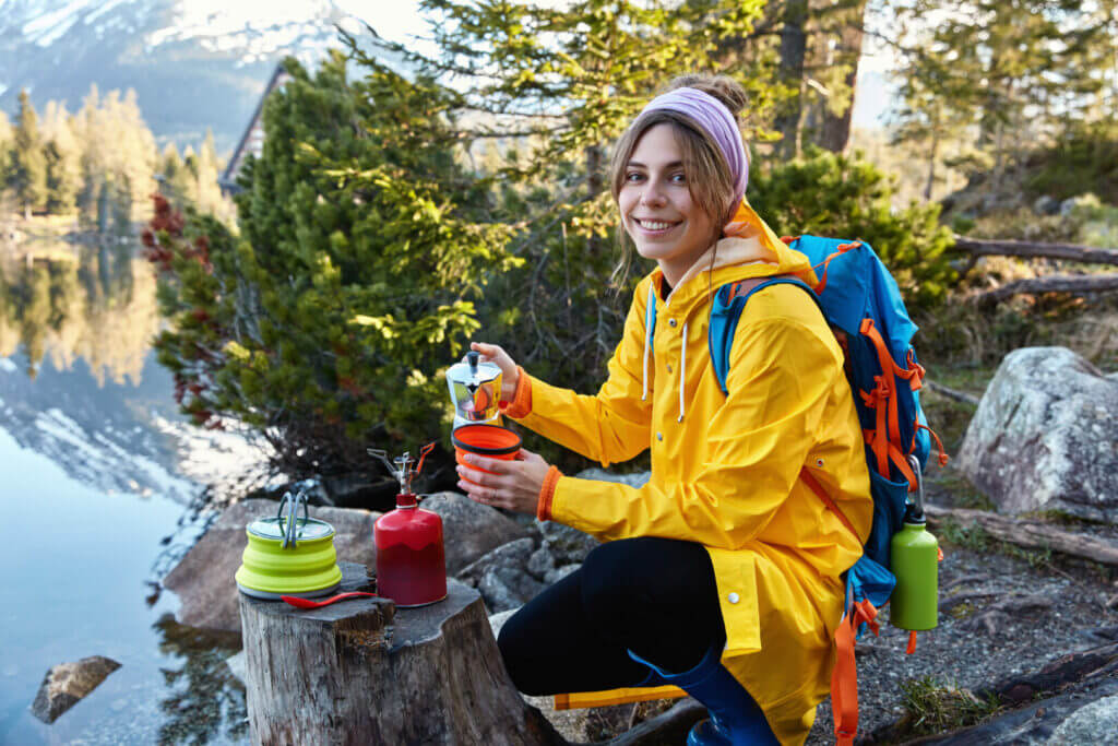 A woman enjoying coffee outdoors, thanks to her RV coffee maker.