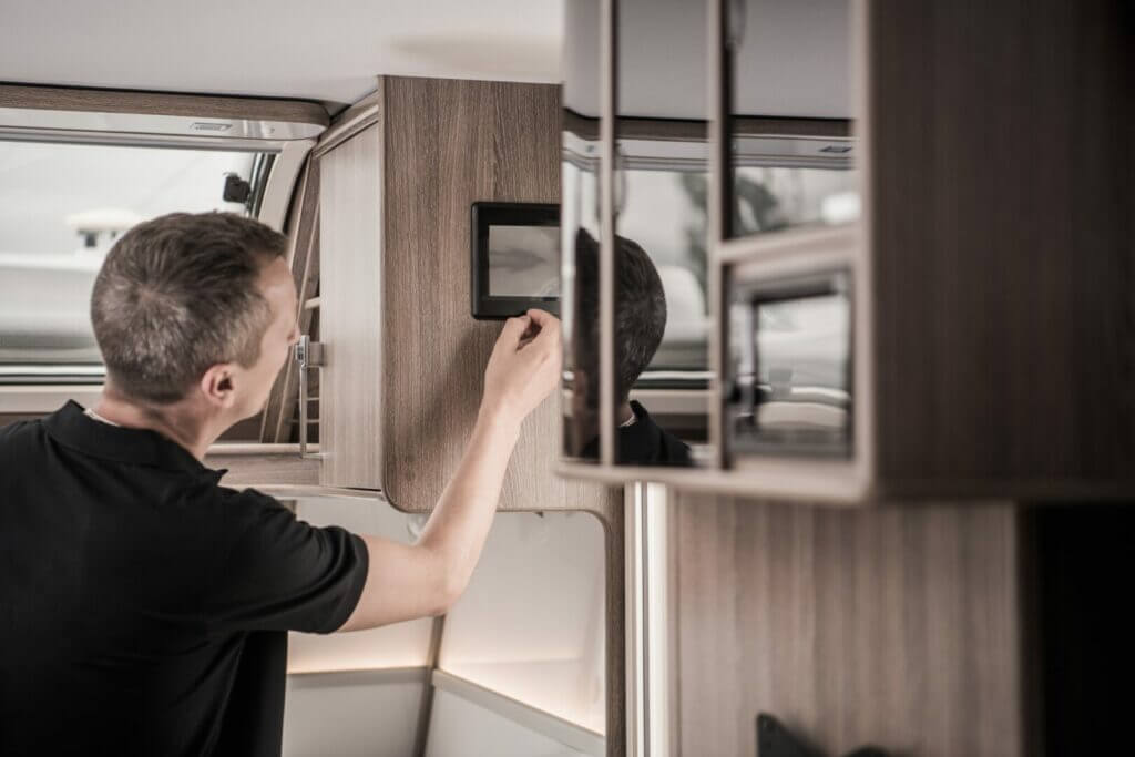 A man adjusting his RV cabinet latches.