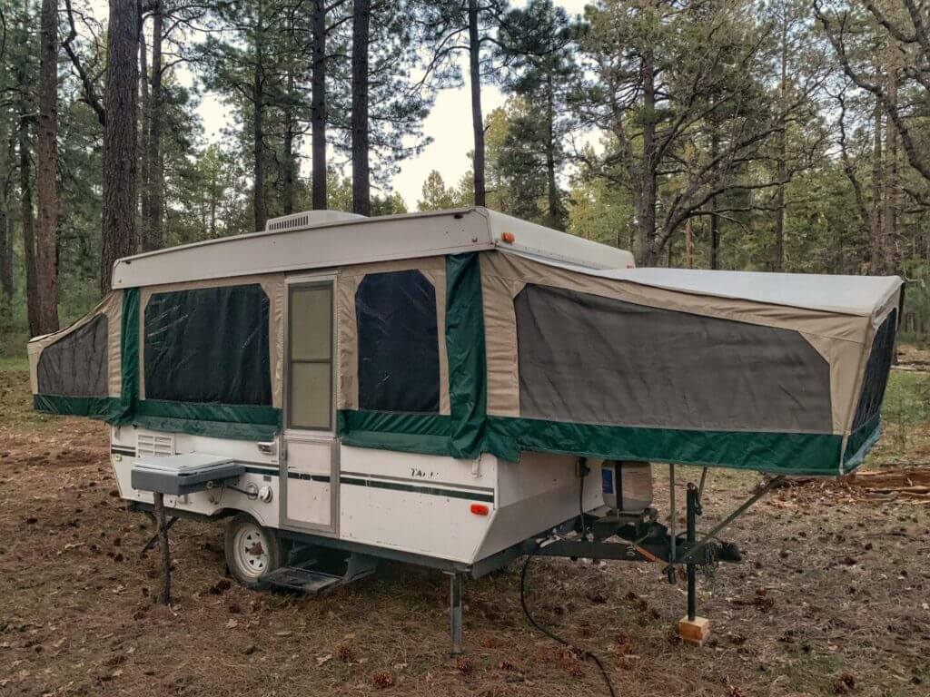 A pop-up camper in the woods.