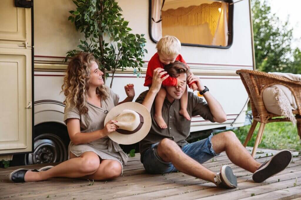 Family playing outside of their travel trailer.