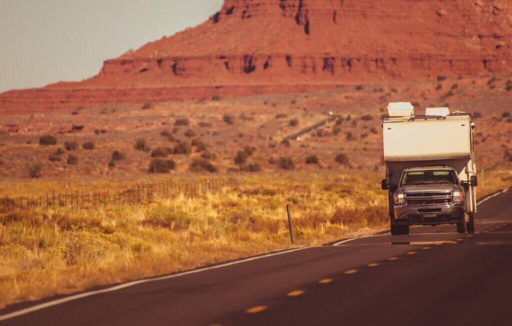 Truck camper driving through the desert in Arizona.