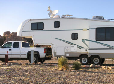 A truck has a fifth wheel towed behind it and is ready to camp!