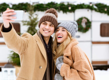 A couple taking a photo in the snow enjoying their new RV cell phone booster.