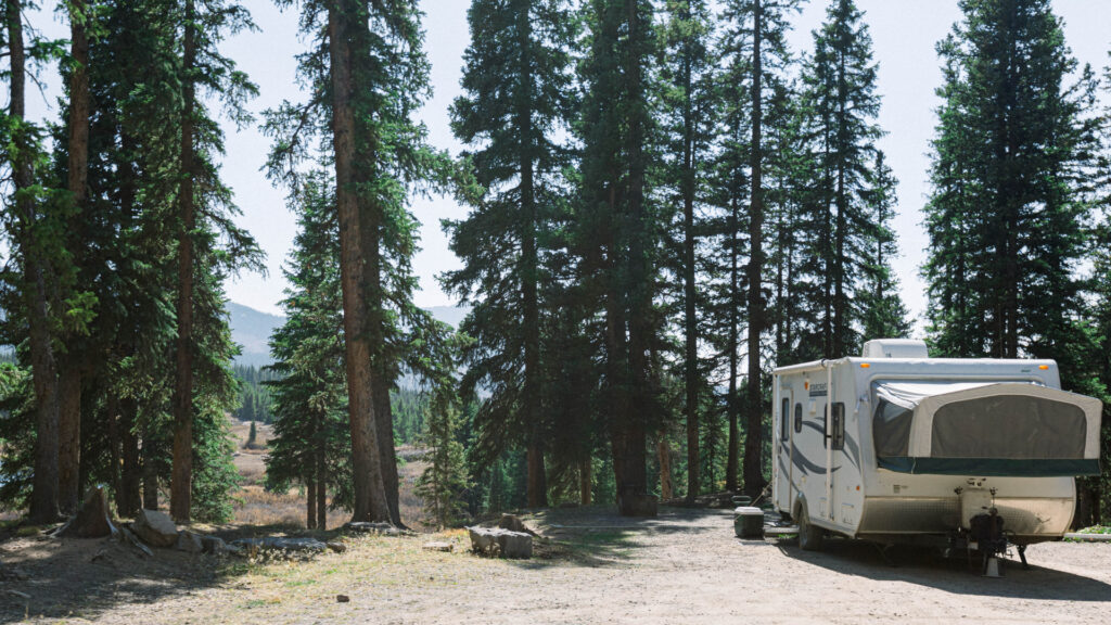 An RV is alone in the woods where it is dispersed camping. 