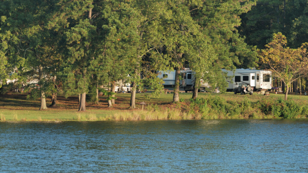 A COE campground with RVs and trees set against the lake.