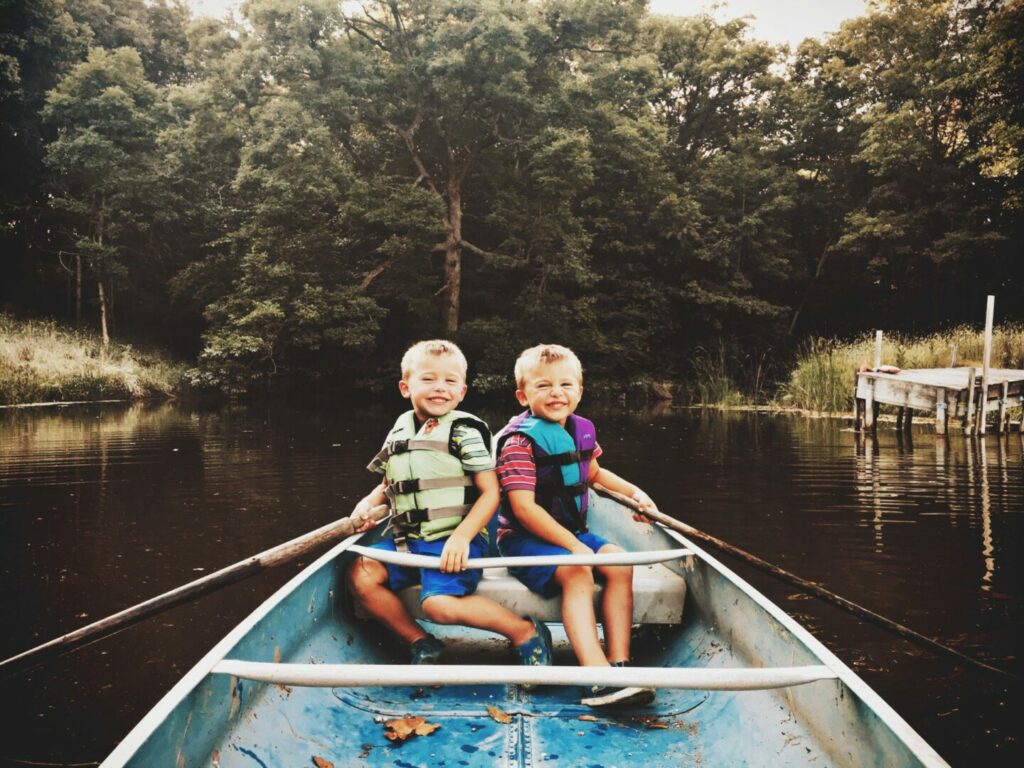 Two young brothers canoeing together.