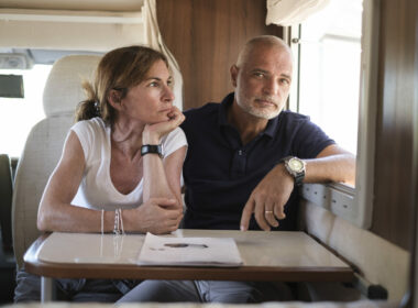 A married couple sitting in an RV looking disappointed
