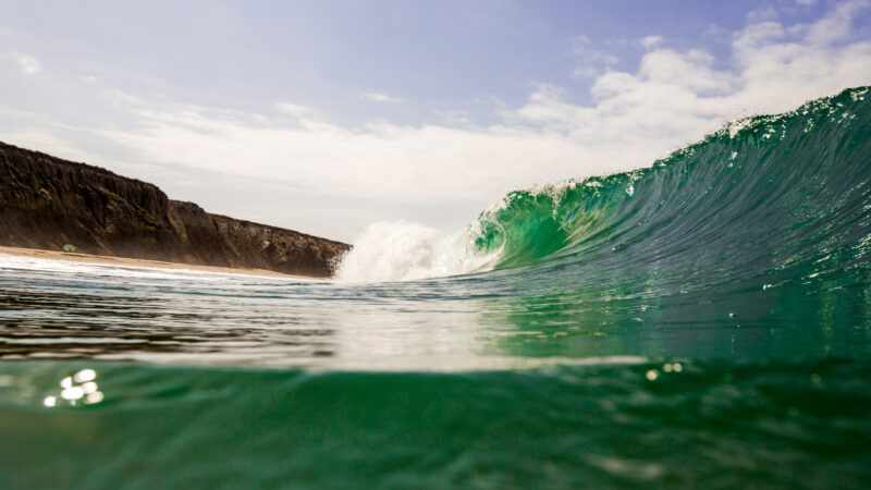 Jalama beach camping is a great surf spot with green ocean waves crashing on the shore.