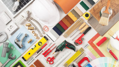 A variety of colorful RV renovation tools and paint swatches laid out.