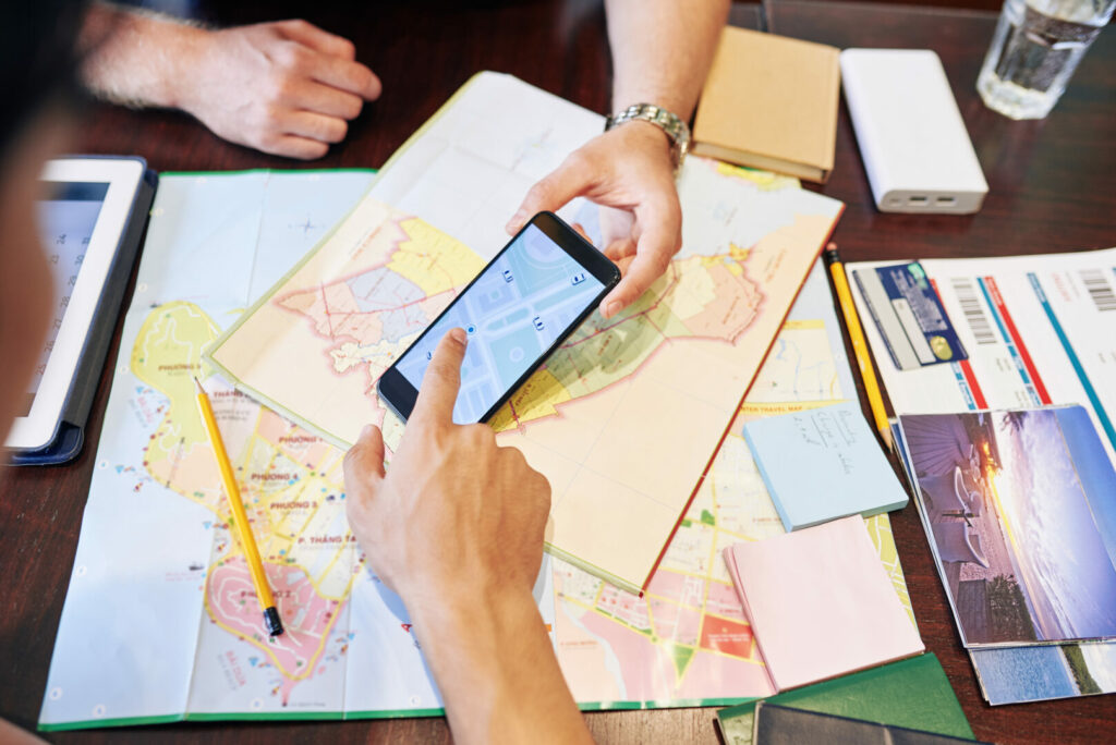 Close-up image of friends checking map on smartphone when planning an RV road trip