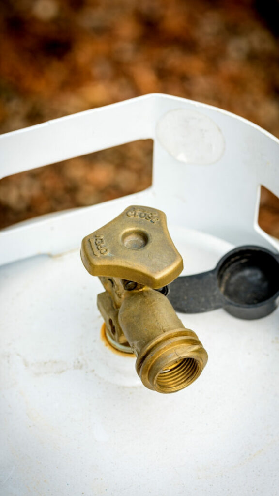 Close up of the brass knob on top of a propane tank.