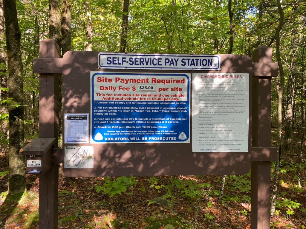 A campground sign with the fees and rules.