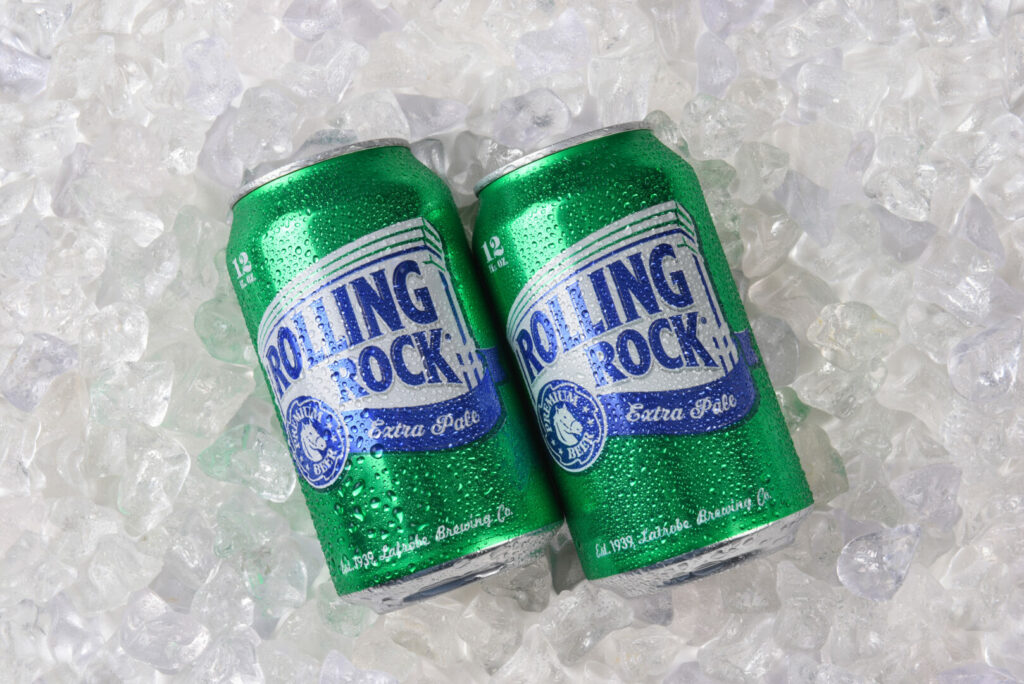 Two cans of Rolling Rock cheap beer on ice