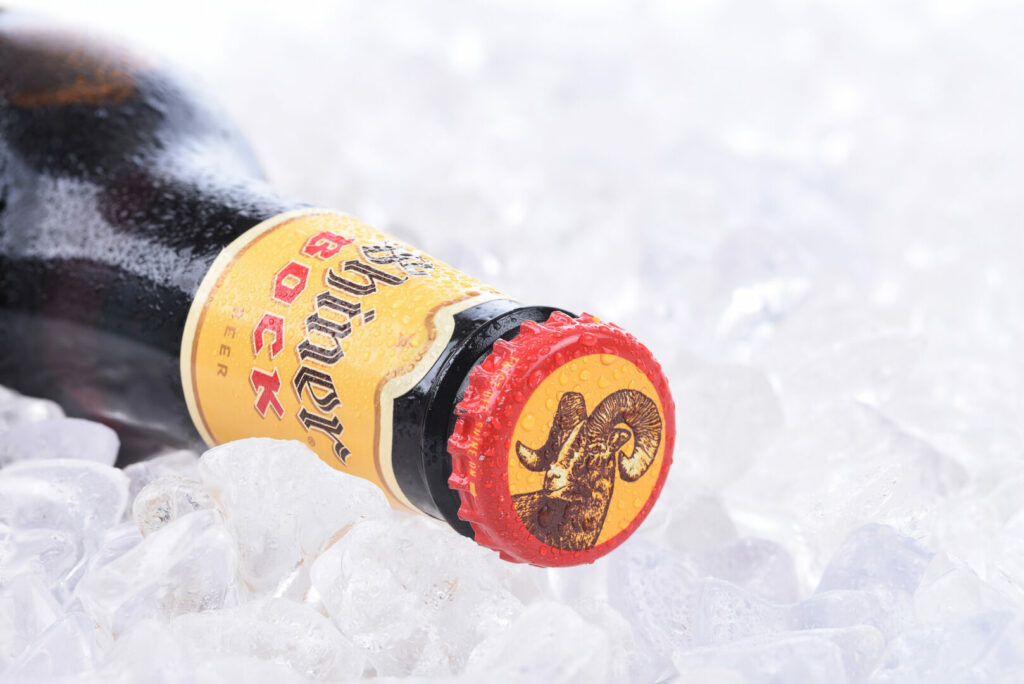 A close up shot of a glass bottle of Shiner Bock on ice