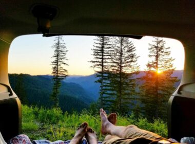 Free camping in Tillamook, Oregon as the sun rises over the hills looking out the back hatch of a vehicle